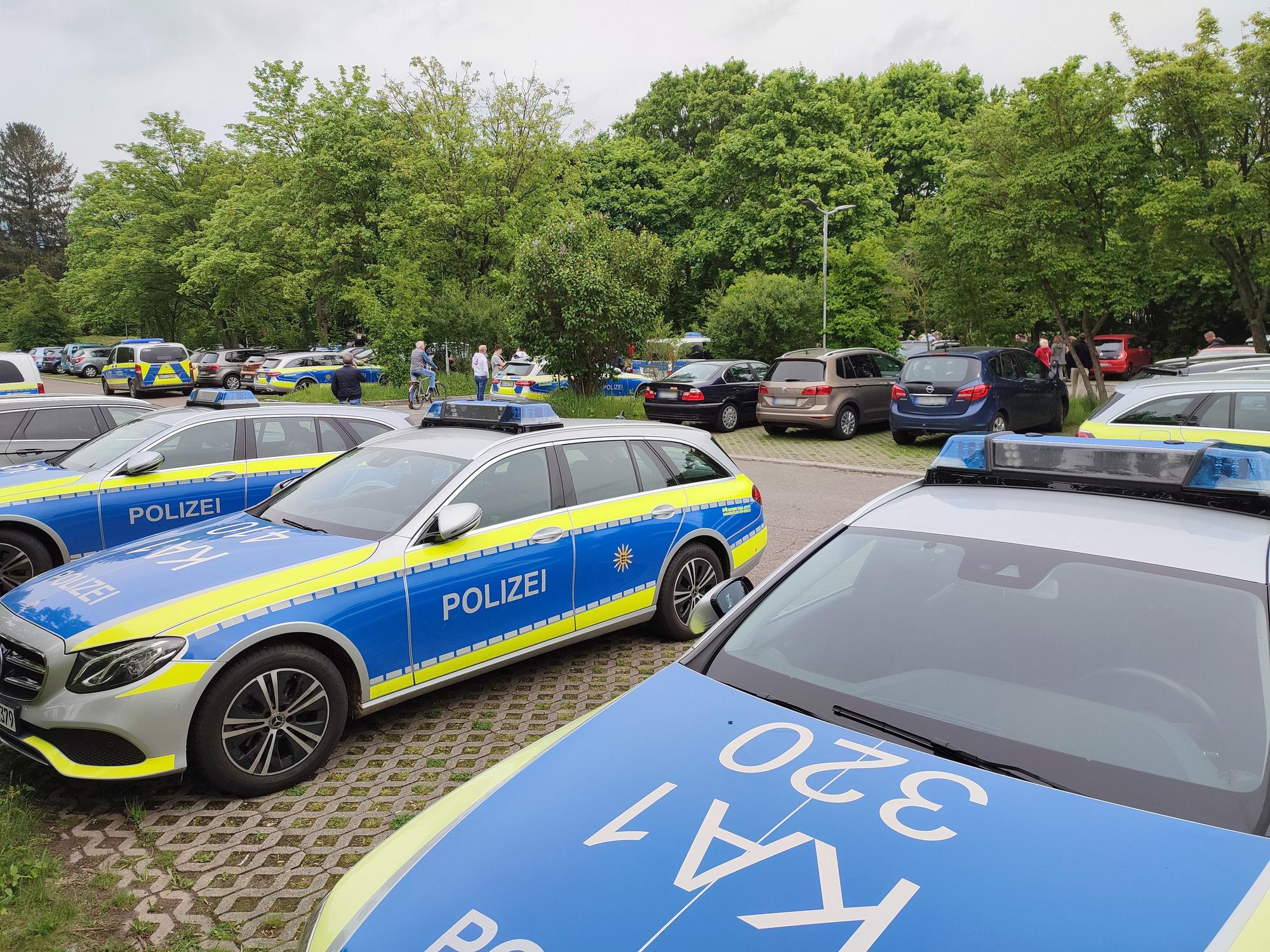 Polizeifahrzeuge stehen auf einem Parkplatz nahe einer Schule.