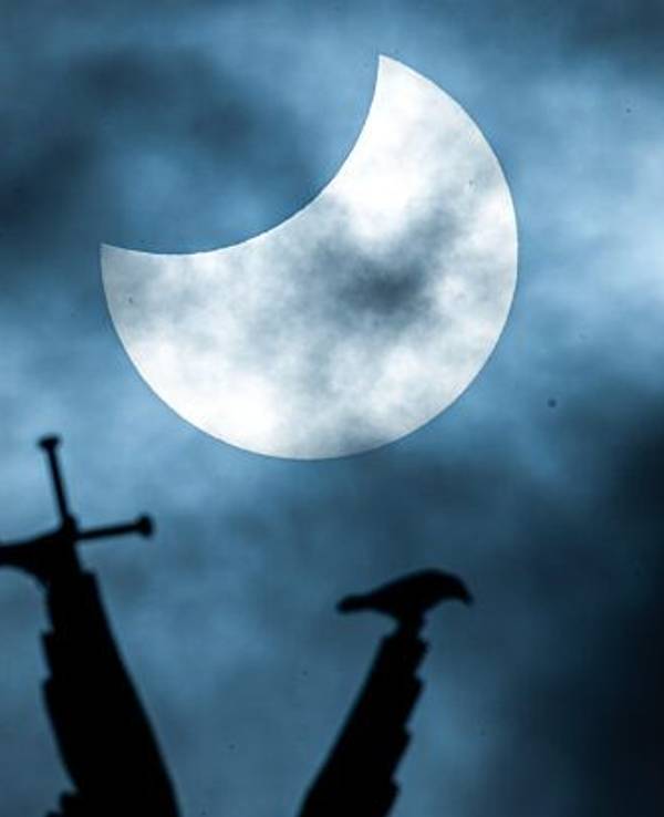 Eine partielle Sonnenfinsternis ist über der vergoldeten Statue des Erzengel Michael auf der Kuppel des Schweriner Schlosses zu sehen.
