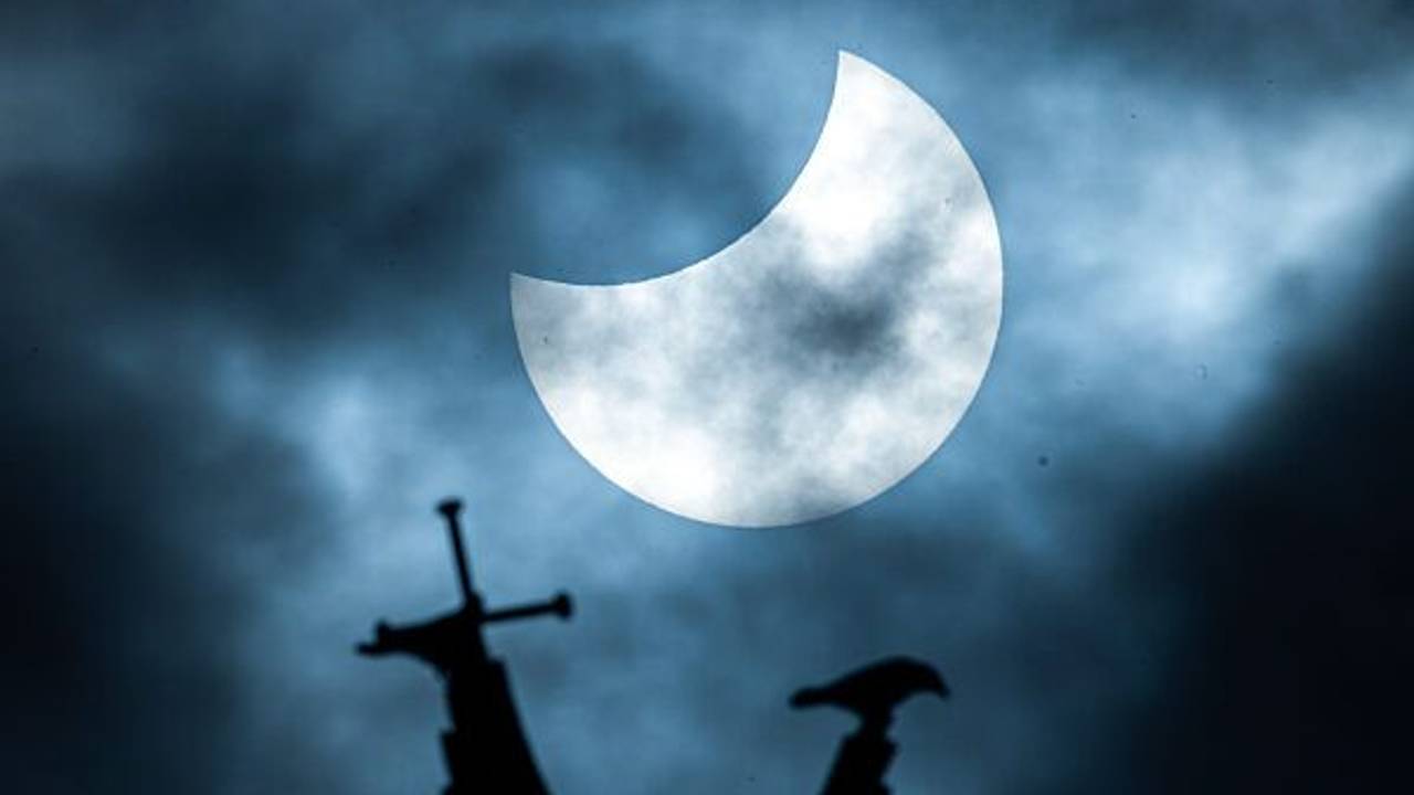 Eine partielle Sonnenfinsternis ist über der vergoldeten Statue des Erzengel Michael auf der Kuppel des Schweriner Schlosses zu sehen.