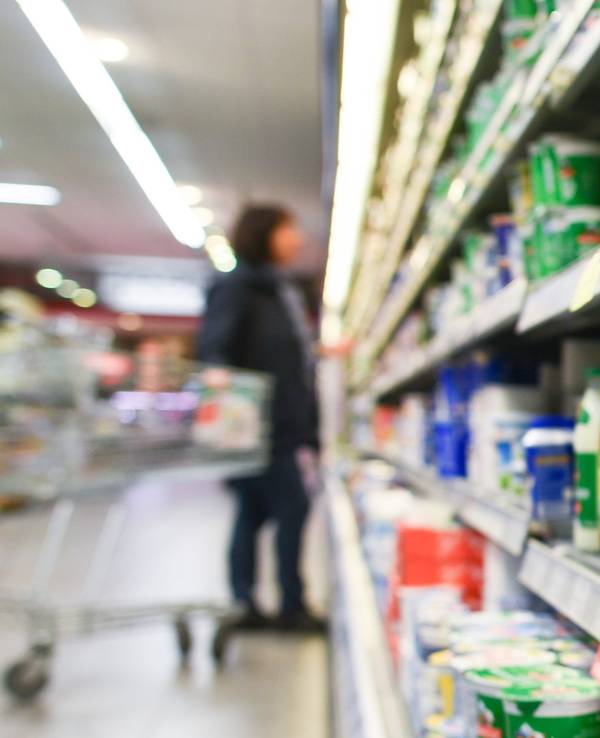 Eine Kundin steht in einem Supermarkt (Symbolfoto) vor einem Kühlregal.