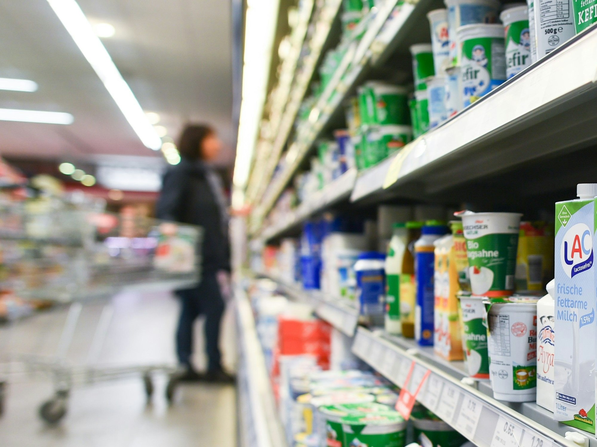 Eine Kundin steht in einem Supermarkt (Symbolfoto) vor einem Kühlregal.