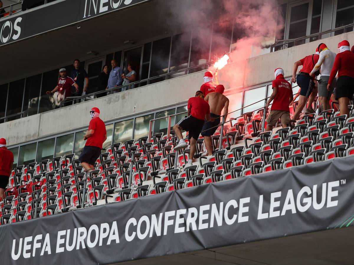 Fans laufen mit Pyrotechnik über eine Tribüne.