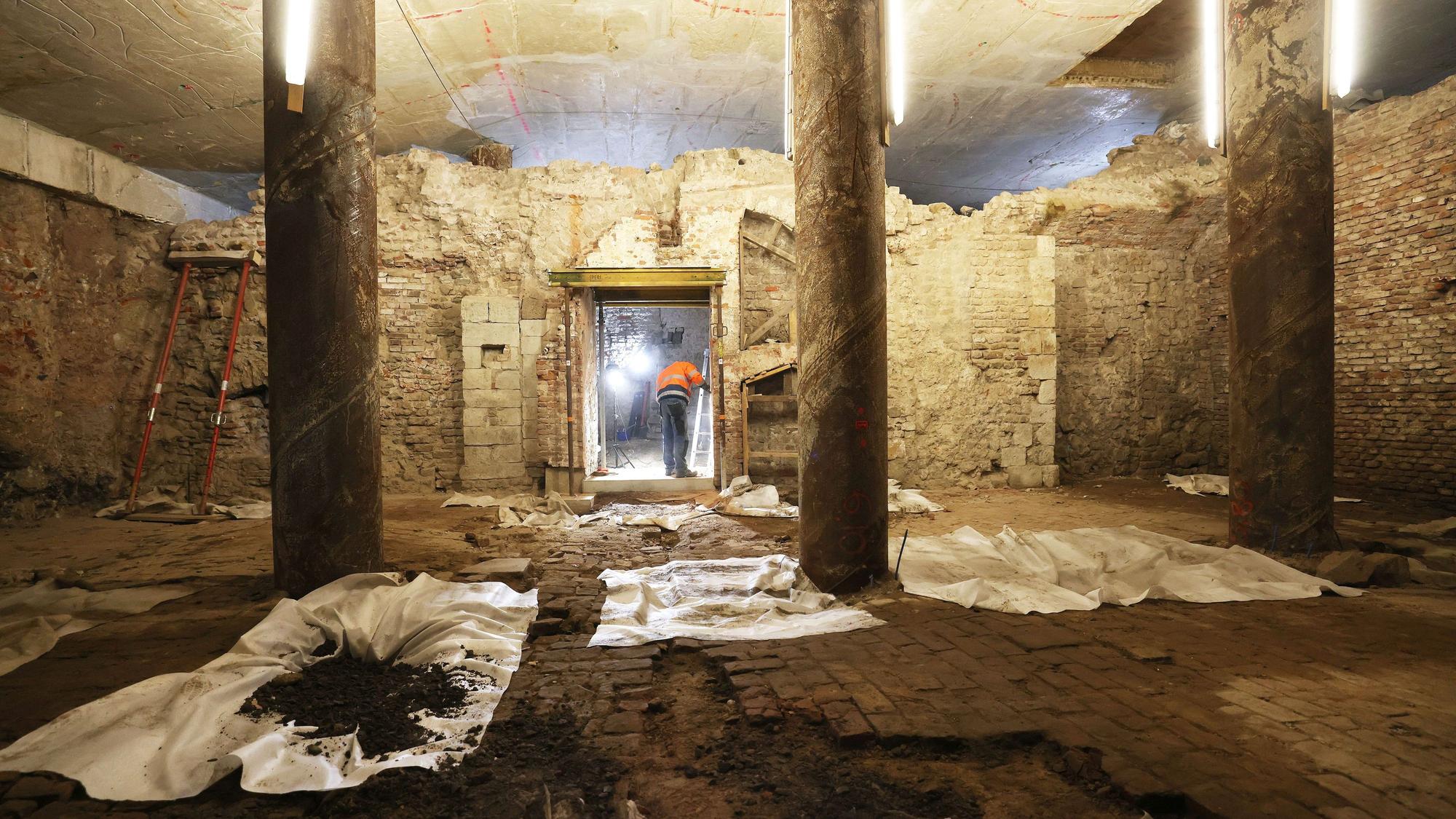 Ein Archäologen arbeitet auf dem Gelände des Jüdischen Museums im Archäologischen Quartier (MiQua) an Mauerresten.
