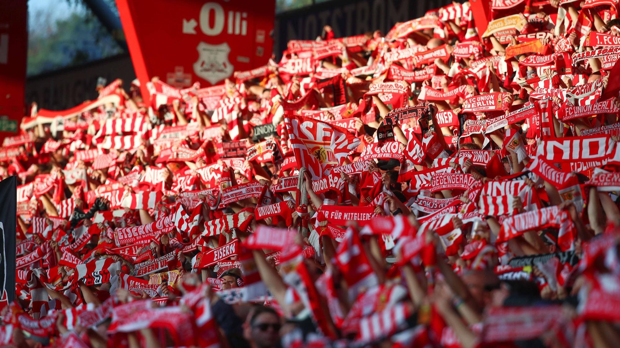 Zahlreiche Fans von Union Berlin halten ihre Schals in die Höhe.