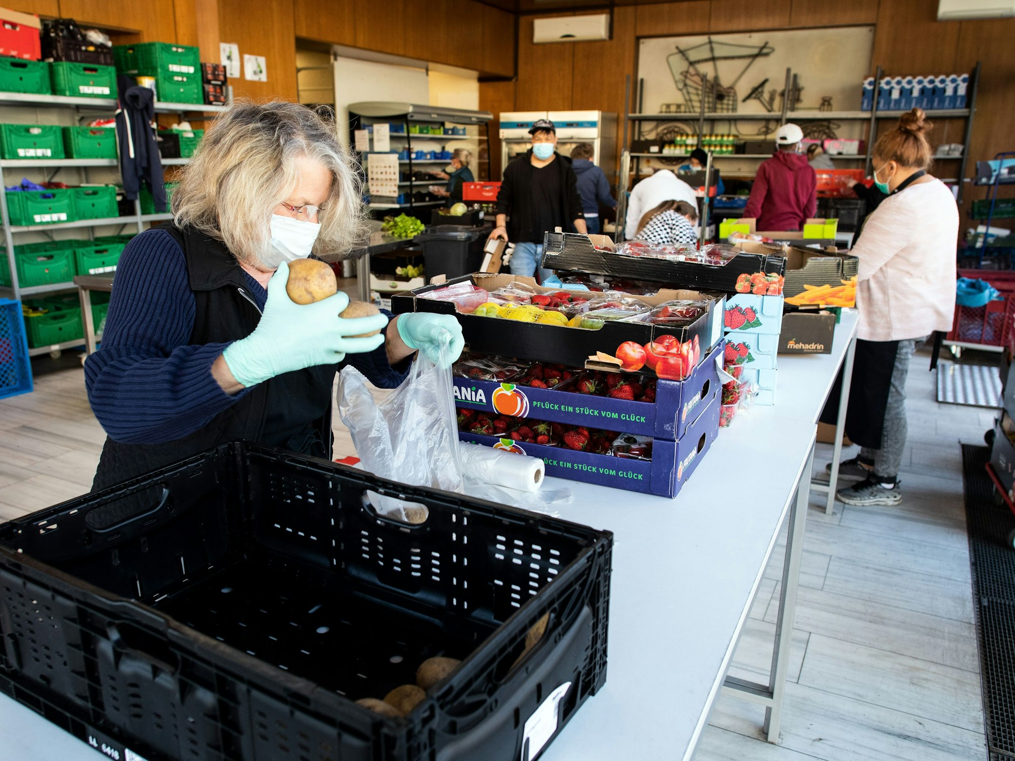 Mitarbeiterinnen von der Tafel Dormagen e.V. bereiten Lebensmittel zur Verteilung vor.