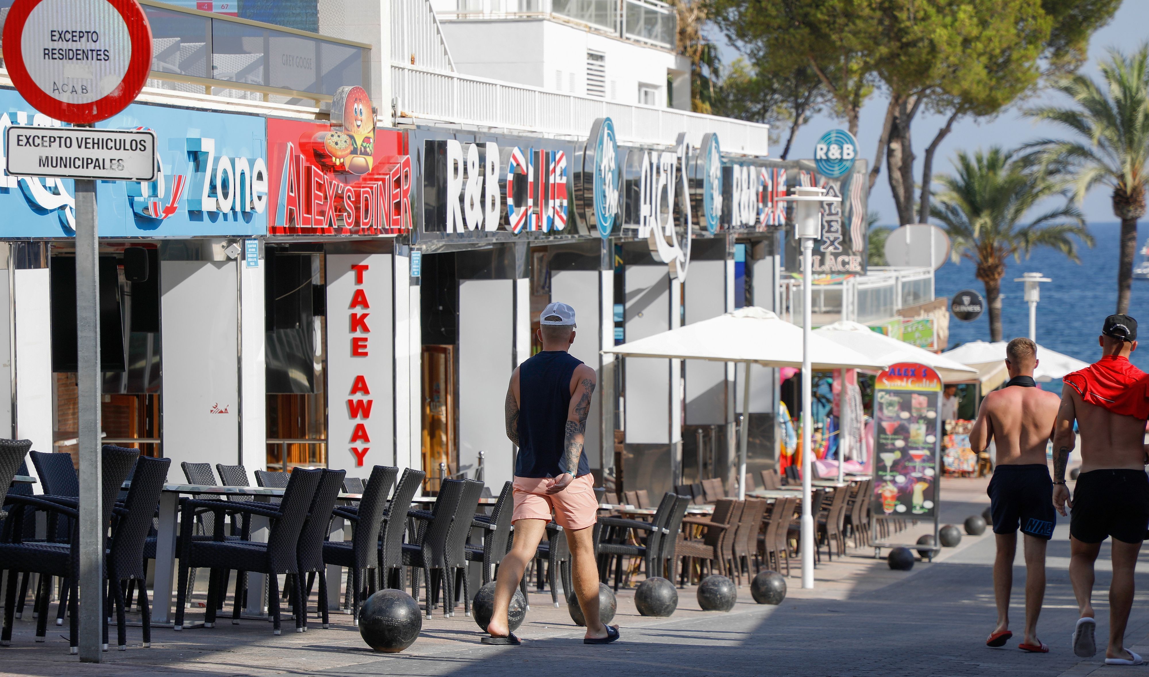 Menschen spazieren durch die Party-Hochburg Magaluf.