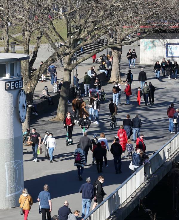 Menschen laufen über die Rheinpromenade in der Kölner Altstadt.