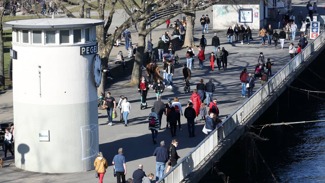 Menschen laufen über die Rheinpromenade in der Kölner Altstadt.