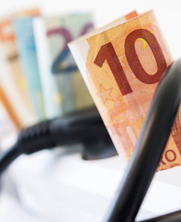 Euro-Scheine stecken in einer Mehrfachsteckdose mit Kippschalter.