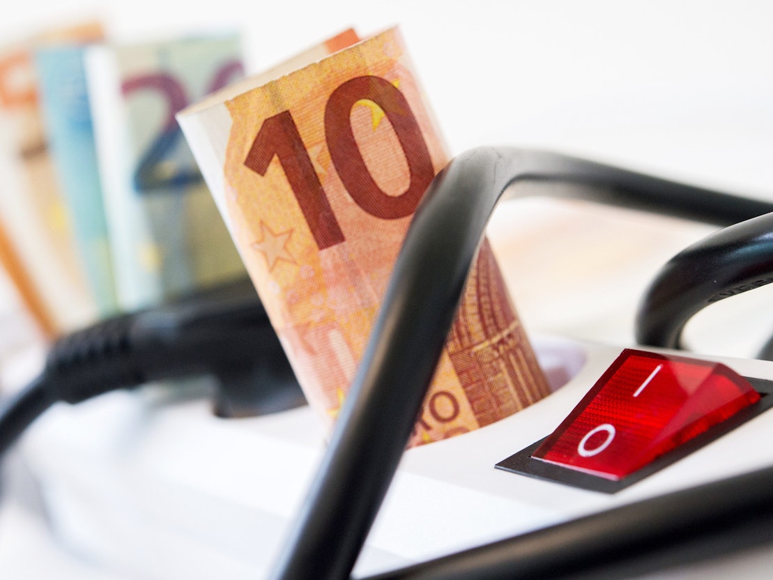 Euro-Scheine stecken in einer Mehrfachsteckdose mit Kippschalter.