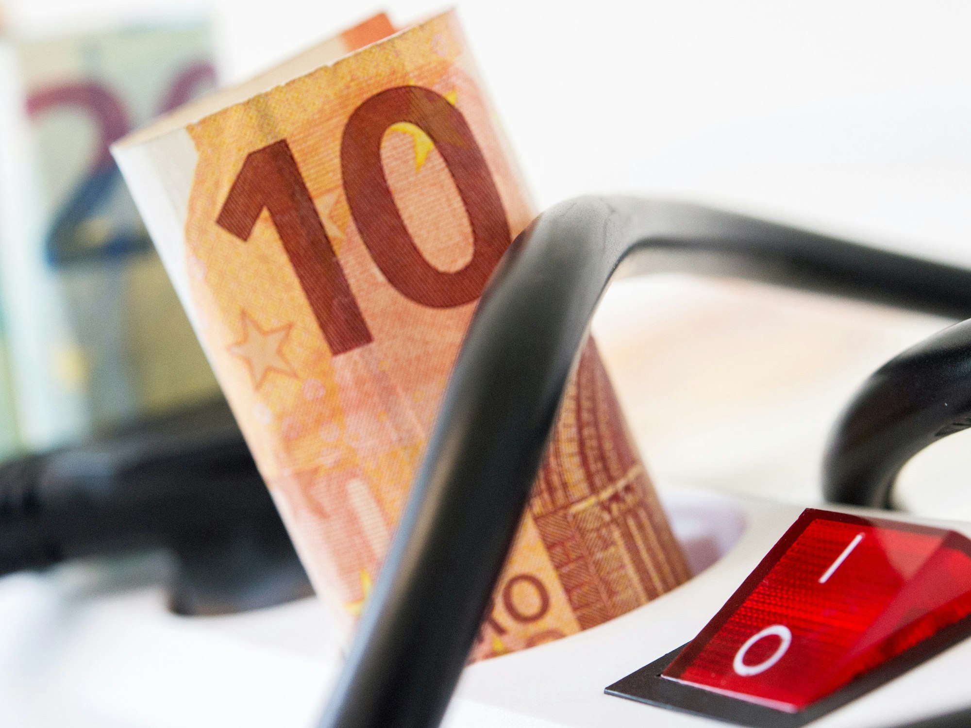 Euro-Scheine stecken in einer Mehrfachsteckdose mit Kippschalter.