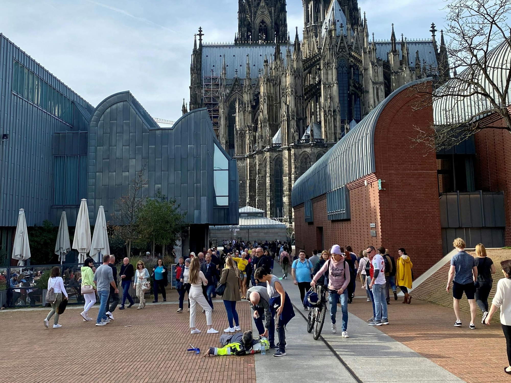 Ein Sicherheitsmann liegt auf dem Heinrich-Böll-Platz auf dem Boden.