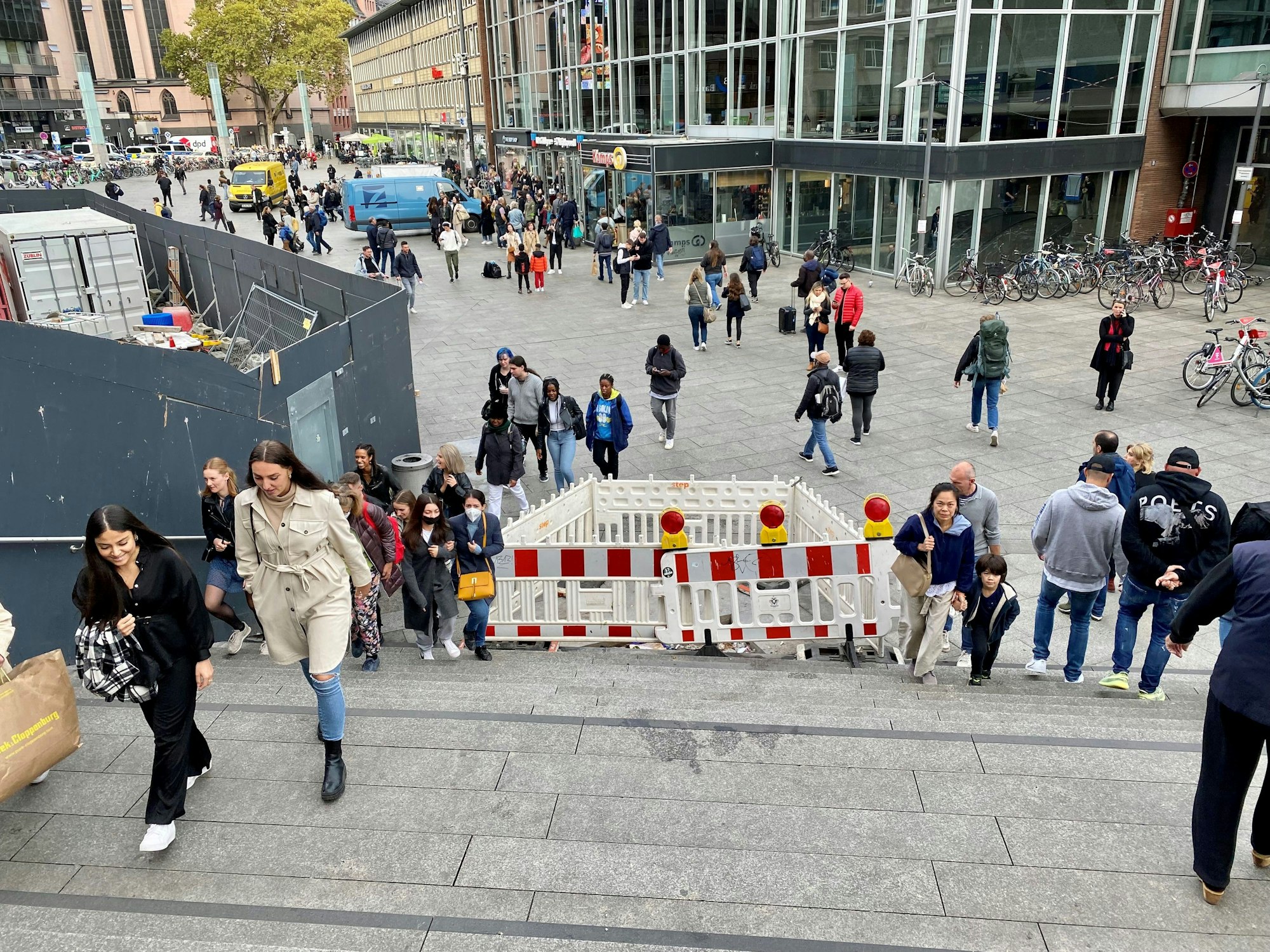Passanten und Passantinnen laufen über die Domtreppe, auf der ein Teil abgesperrt ist.