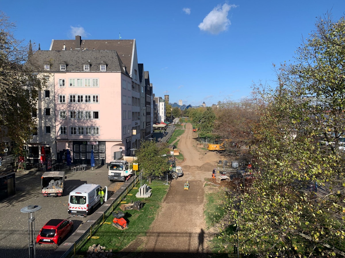 Für die Fahrrad-Umleitung am Pegel in der Kölner Altstadt wird Rasen an der Rheinpromenade abgetragen.