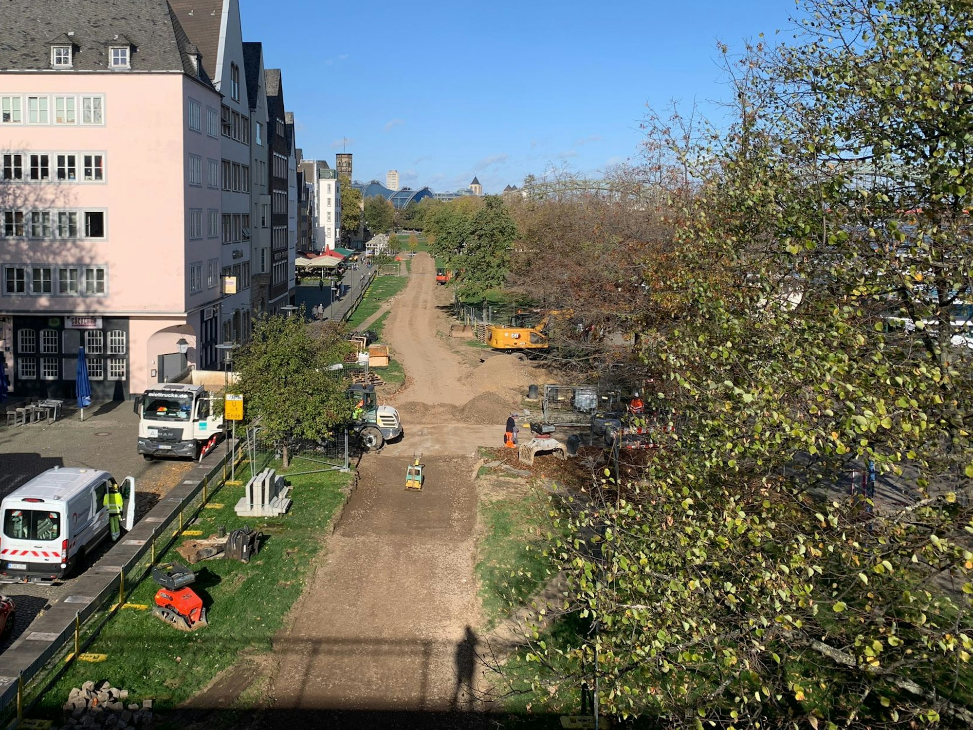 Für die Fahrrad-Umleitung am Pegel in der Kölner Altstadt wird Rasen an der Rheinpromenade abgetragen.