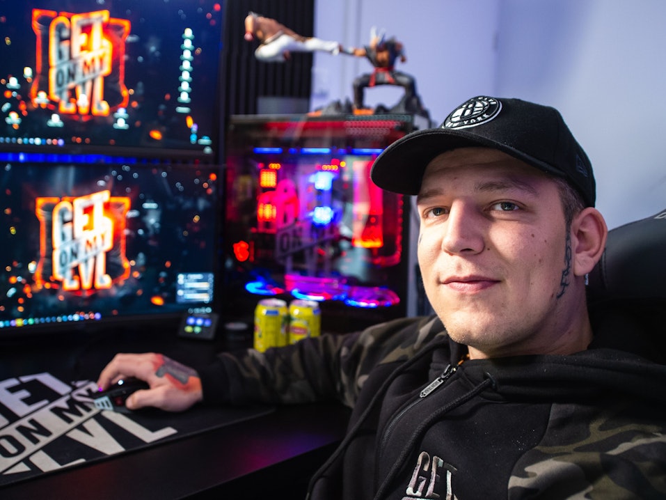 Marcel Eris, YouTuber, sitzt in seinem Arbeitszimmer am Tisch vor Computermonitoren.