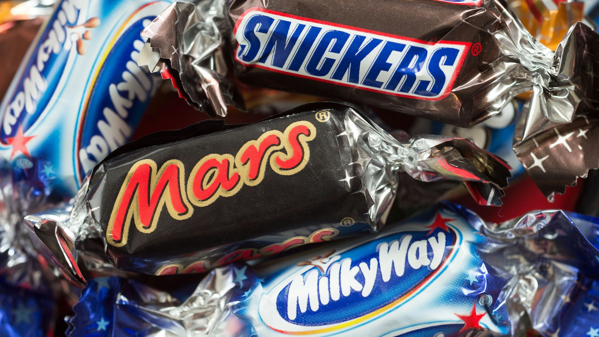 Verschiedene Mars-Schokoriegel liegen auf einem Tisch.