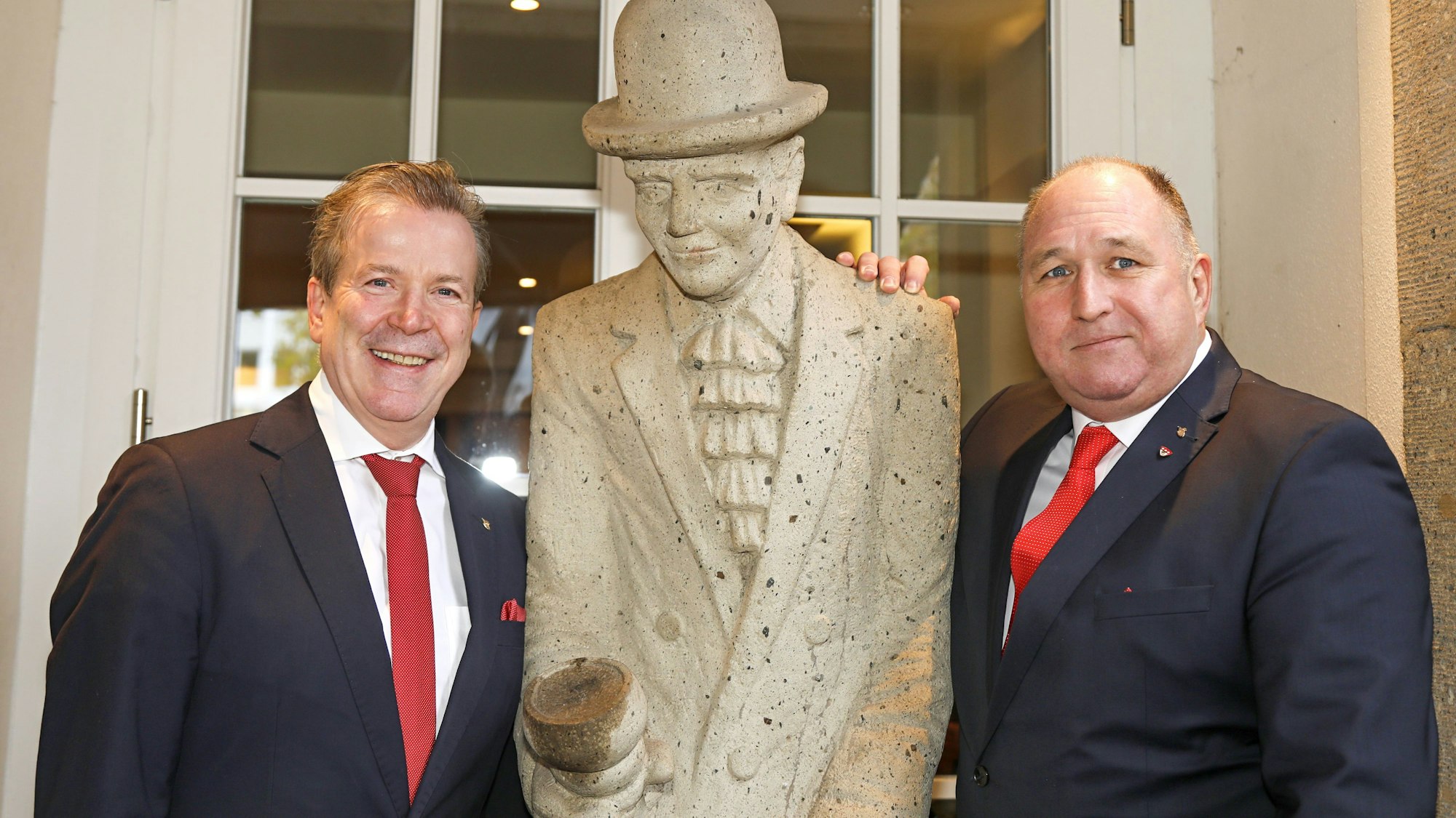 Festkomitee-Präsident Christoph Kuckelkorn (l.) und Ostermann-Chef Ralf Schlegelmilch neben der Figur von Willi Ostermann.