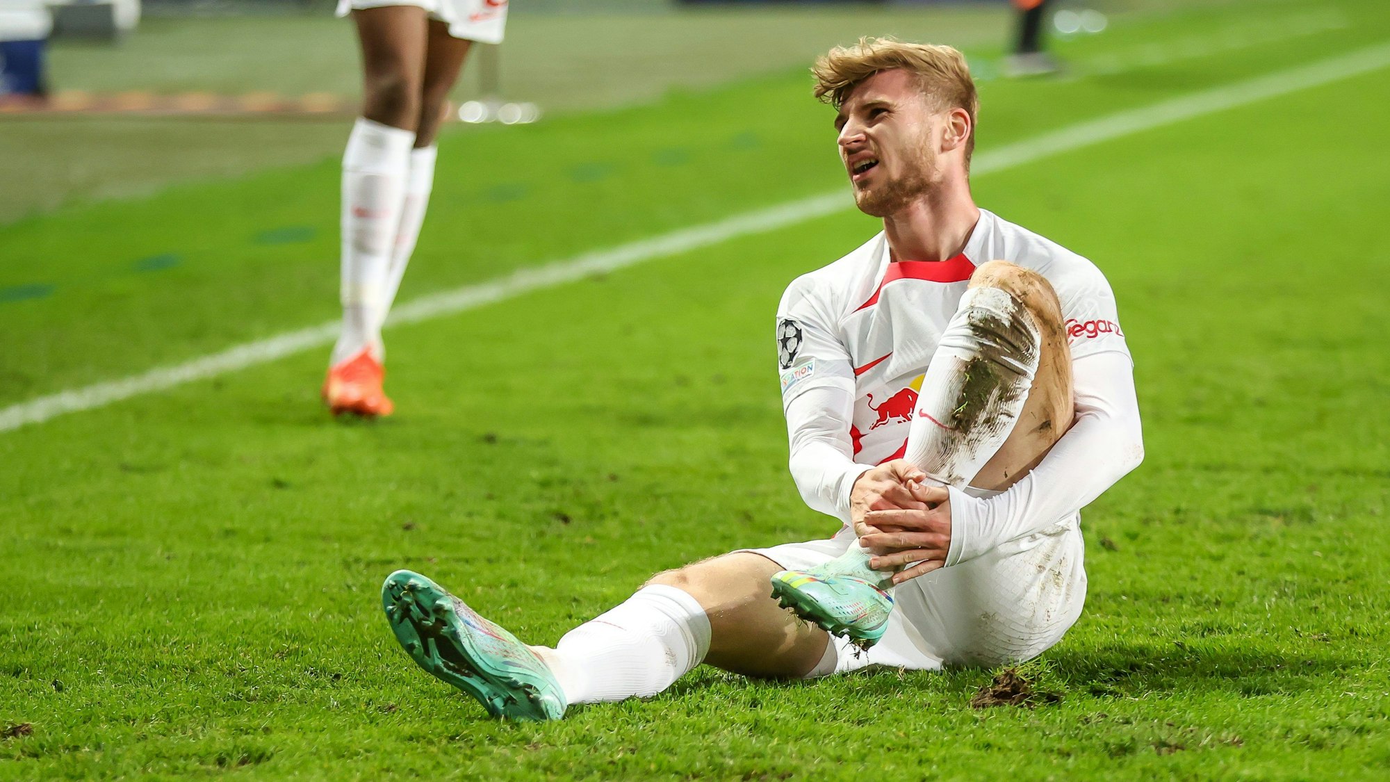 Timo Werner sitzt kurz nach seiner Verletzung im Spiel von RB Leipzig bei Schachtjor Donezk auf dem Rasen.