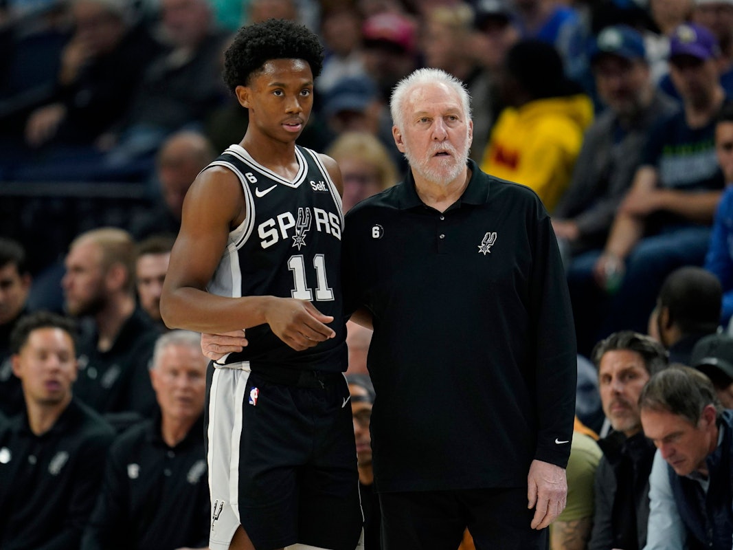 Joshua Primo (11) steht mit Coach Gregg Popovich am Spielfeldrand.