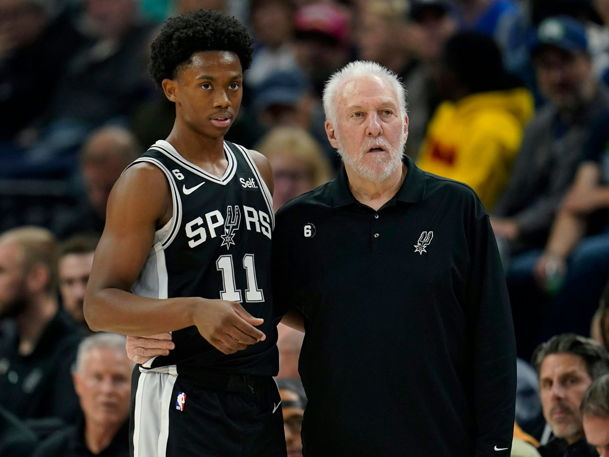 Joshua Primo (11) steht mit Coach Gregg Popovich am Spielfeldrand.