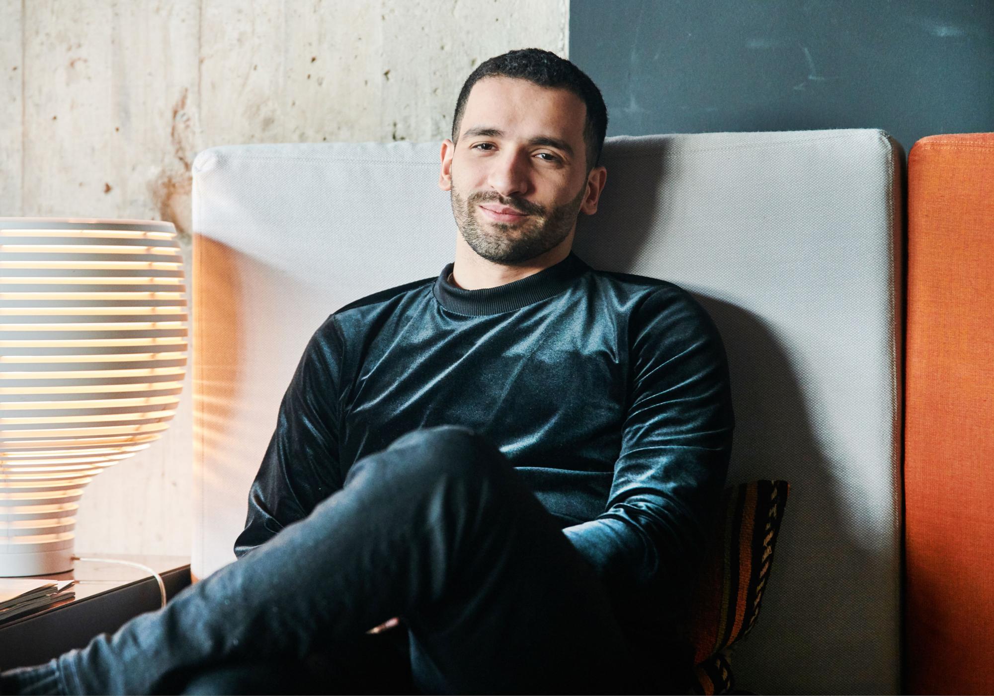 Schauspieler Hassan Akkouch sitzt auf der Couch im 25hours Hotel Bikini Berlin.