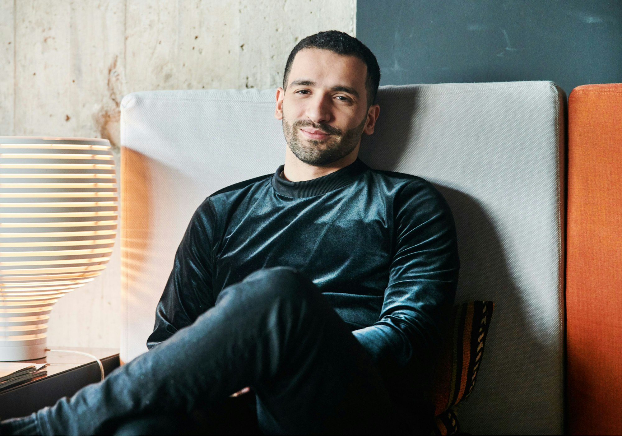 Schauspieler Hassan Akkouch sitzt auf der Couch im 25hours Hotel Bikini Berlin.