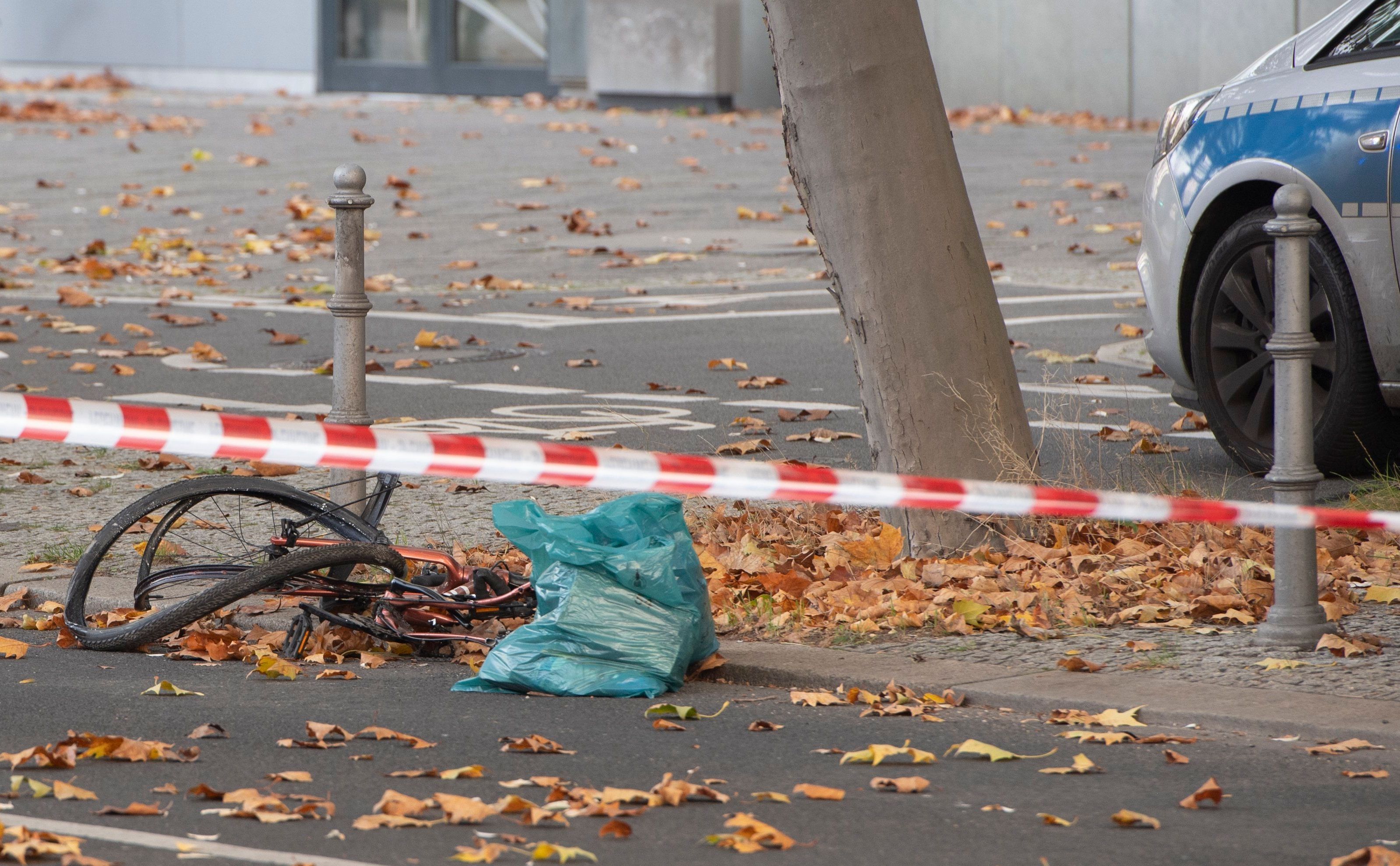 Ein zerstörtes Fahrrad liegt auf an einer Straße, die mit Flatterband der Polizei in dem Bereich abgesperrt wurde.