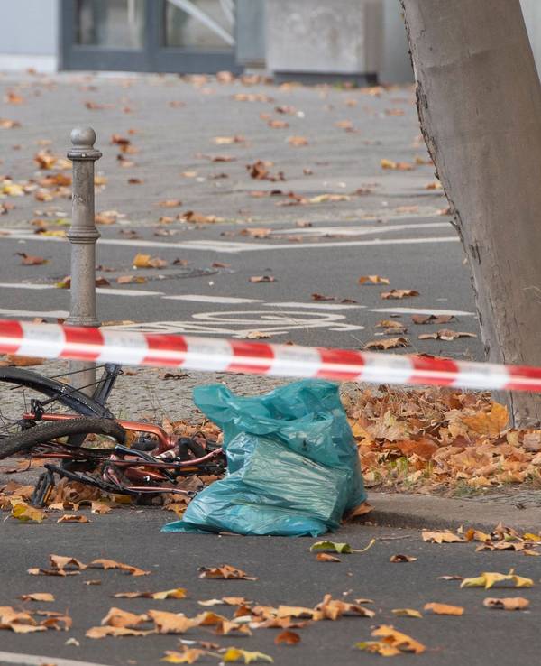 Ein zerstörtes Fahrrad liegt auf an einer Straße, die mit Flatterband der Polizei in dem Bereich abgesperrt wurde.