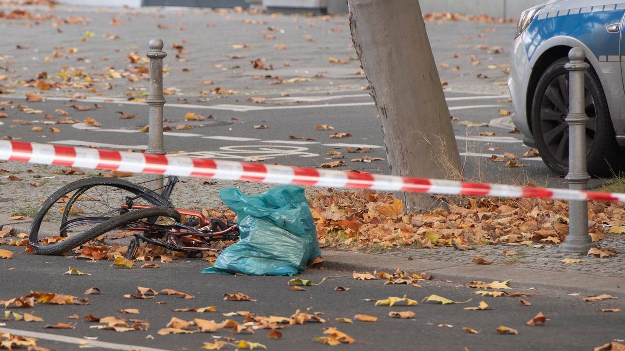 Ein zerstörtes Fahrrad liegt auf an einer Straße, die mit Flatterband der Polizei in dem Bereich abgesperrt wurde.