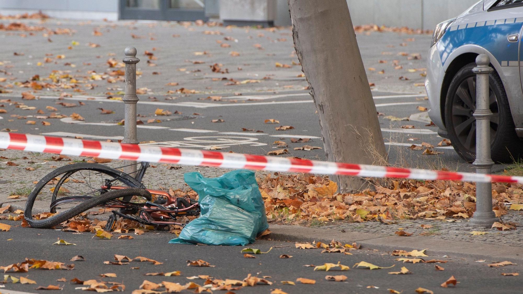 Ein zerstörtes Fahrrad liegt auf an einer Straße, die mit Flatterband der Polizei in dem Bereich abgesperrt wurde.