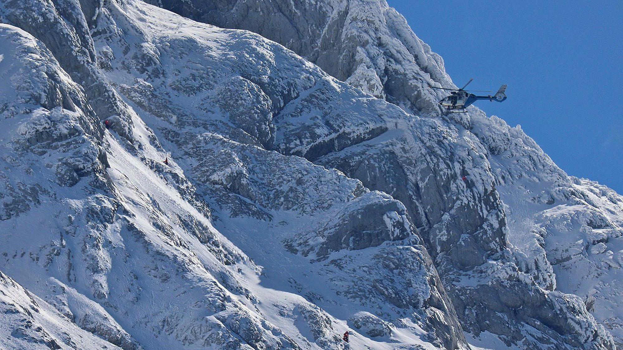 Bergretter suchen am Hochkalter bei Ramsau bei Berchtesgaden bei Schnee unter schwierigen Bedingungen nach einem Bergsteiger.