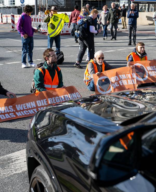 Klimaaktivisten haben sich am Karlsplatz in der Münchner Innenstadt auf die Fahrbahn geklebt und blockieren die Straße.