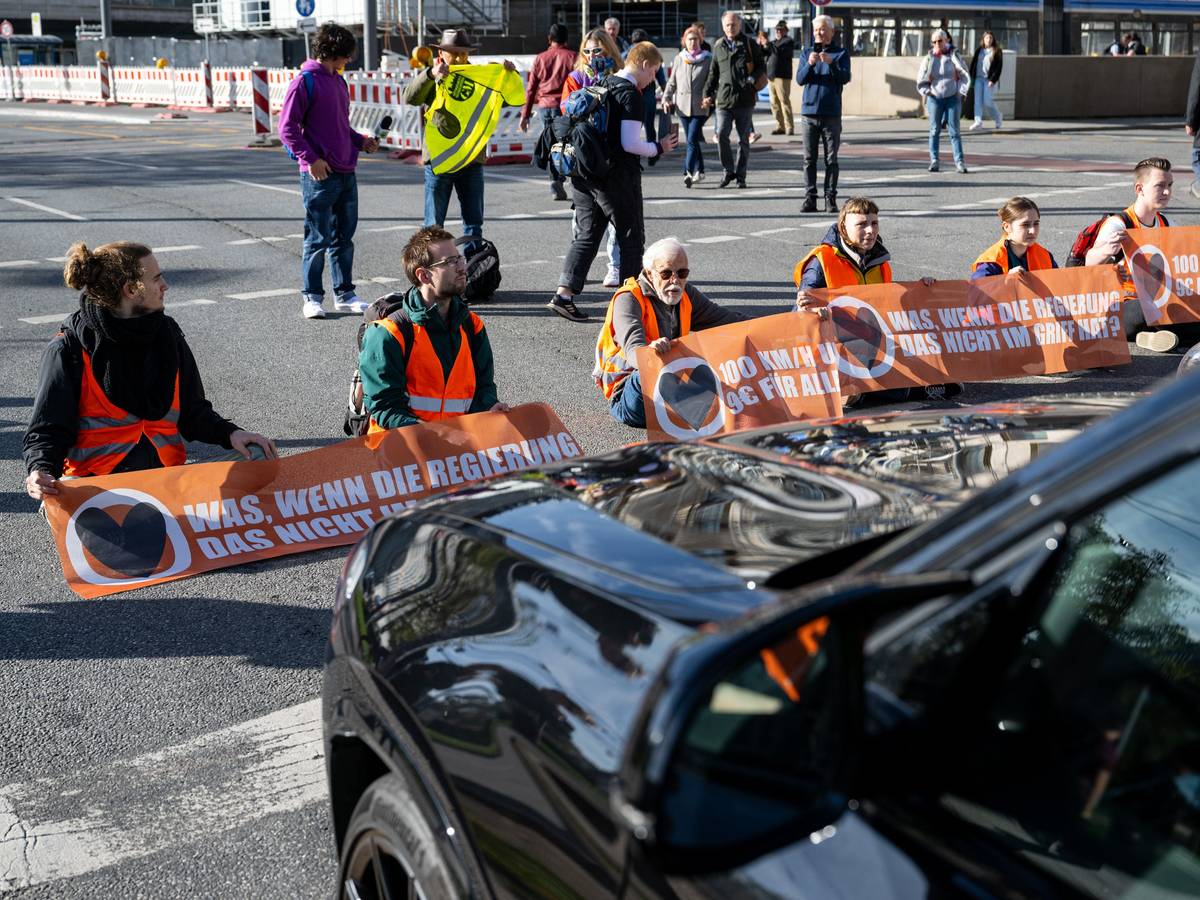 Klimaaktivisten haben sich am Karlsplatz in der Münchner Innenstadt auf die Fahrbahn geklebt und blockieren die Straße.