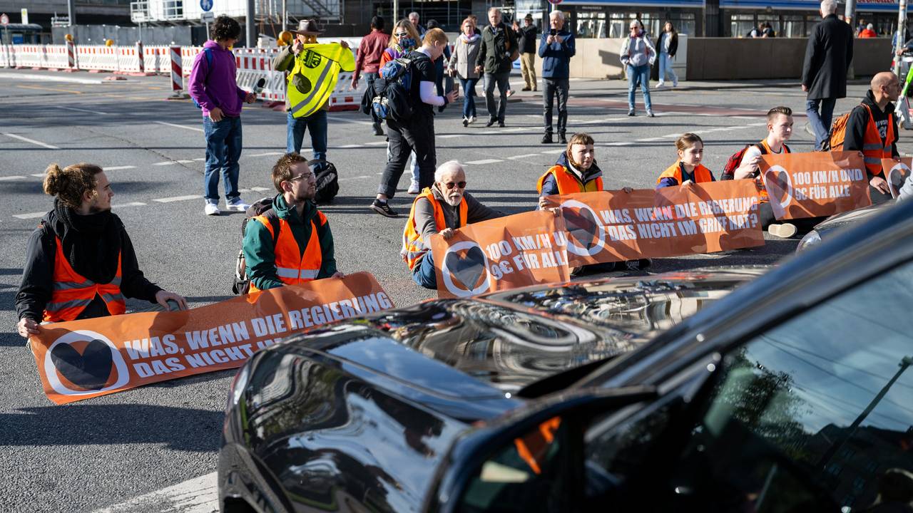 Klimaaktivisten haben sich am Karlsplatz in der Münchner Innenstadt auf die Fahrbahn geklebt und blockieren die Straße.