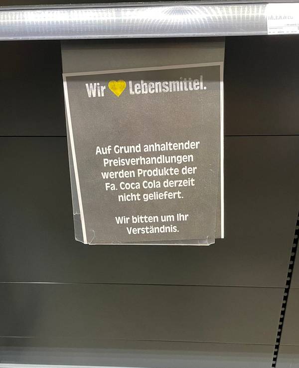 Ein Kunde teilt auf Facebook das Schild in einer Edeka-Filiale, das über die Preisverhandlungen mit Coca-Cola informiert. Aufgrund eines Rechtsstreits sind viele Regale noch leer - zum Unmut der Kundschaft.