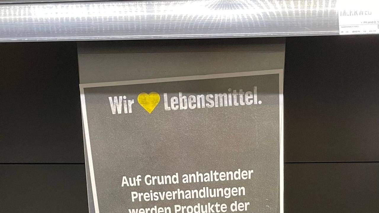 Ein Kunde teilt auf Facebook das Schild in einer Edeka-Filiale, das über die Preisverhandlungen mit Coca-Cola informiert. Aufgrund eines Rechtsstreits sind viele Regale noch leer - zum Unmut der Kundschaft.