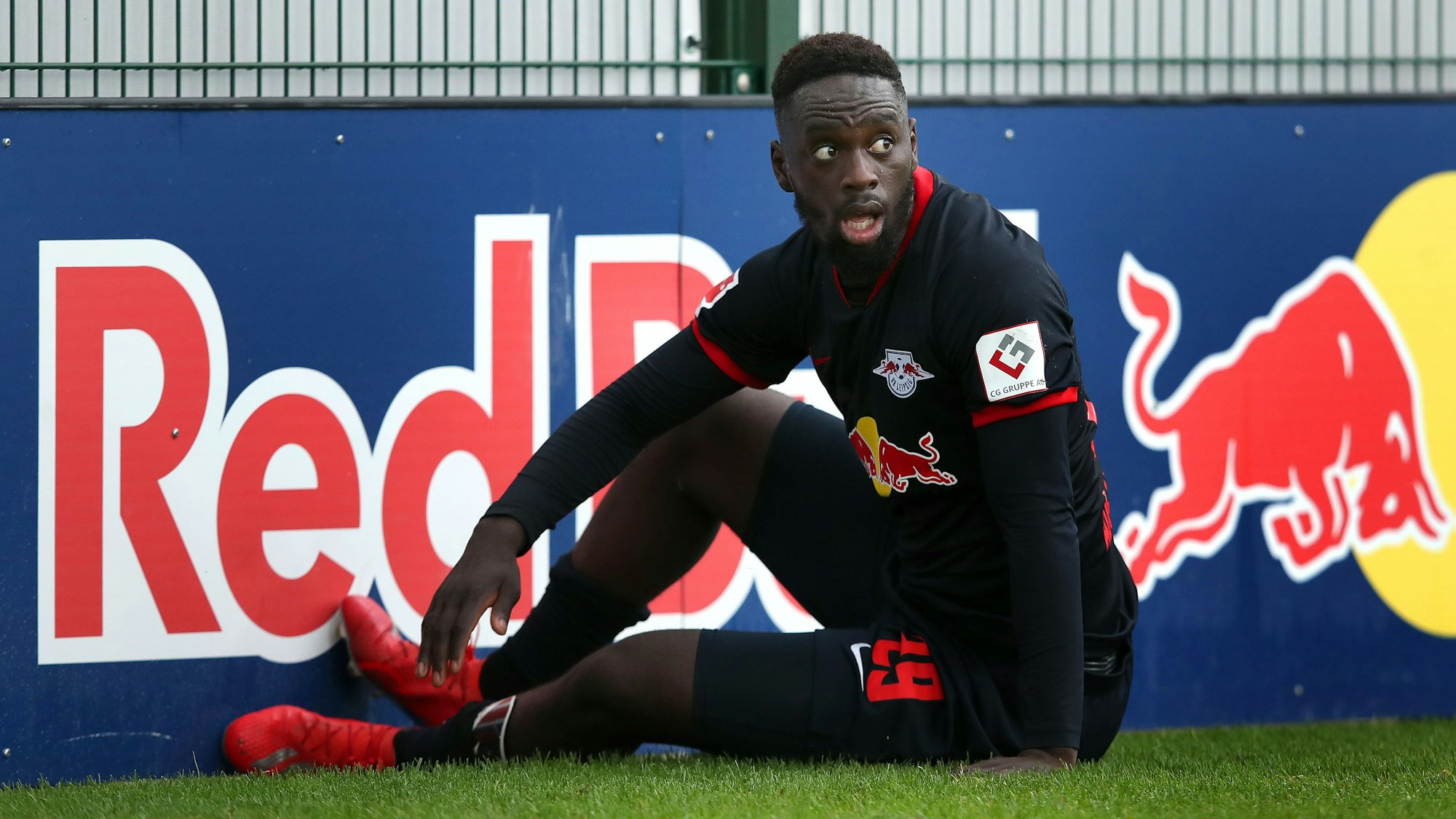 Stürmer Jean-Kévin Augustin sitzt bei einem Spiel von RB Leipzig auf dem Hosenboden