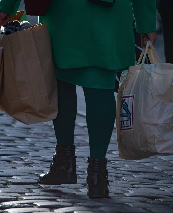 Der Discounter Aldi Süd stimmt Verbraucher auf noch schwierigere Zeiten ein. Unser Archivbild (2021) zeigt eine Frau mit mehreren Einkaufstüten in einer Fußgängerzone in Stralsund.