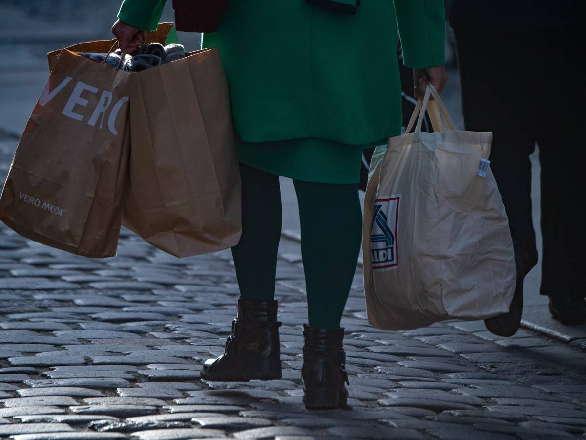 Der Discounter Aldi Süd stimmt Verbraucher auf noch schwierigere Zeiten ein. Unser Archivbild (2021) zeigt eine Frau mit mehreren Einkaufstüten in einer Fußgängerzone in Stralsund.