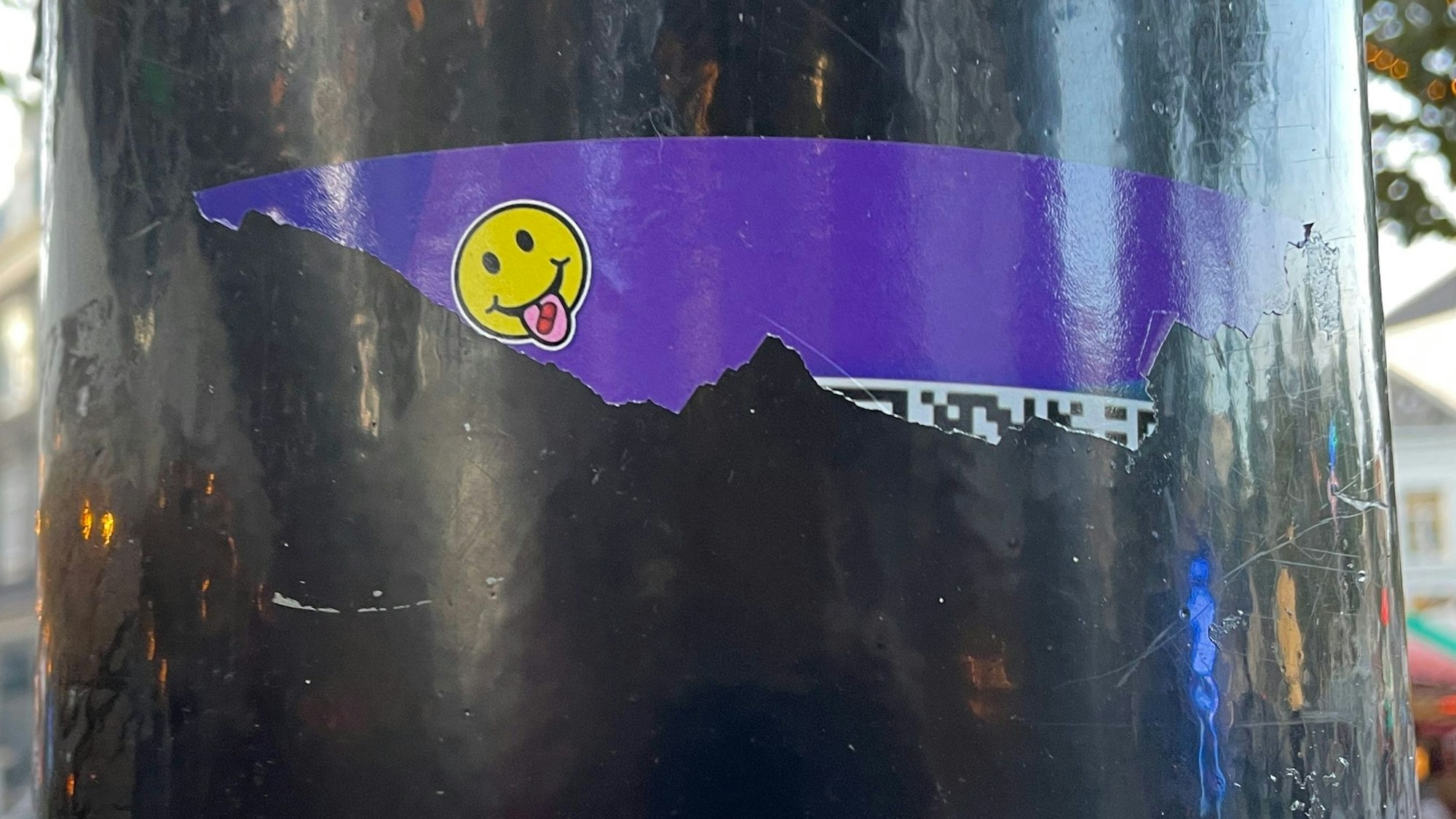 Ein Drogen-Aufkleber an einem Laternenpfahl. In Amsterdam wurden an öffentlichen Plätzen Sticker geklebt, über die man mithilfe eines QR-Codes Drogen wie XTC online bestellen kann. Auch der Verkauf von Lachgas und Cannabis läuft zunehmend über solche Aufkleber.