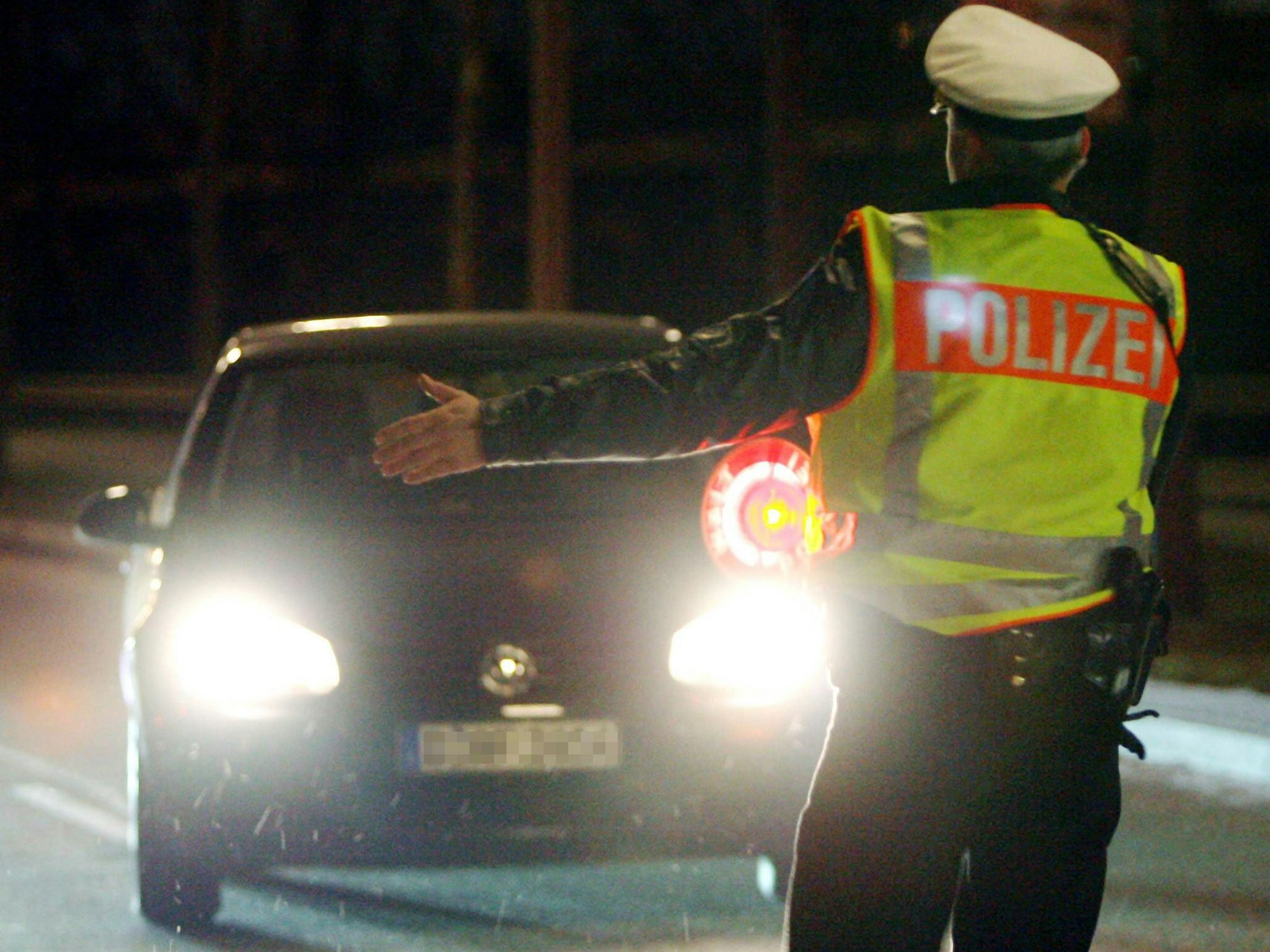 Ein Polizist winkt ein Auto aus dem Verkehr.