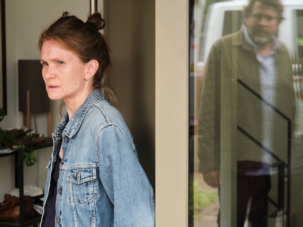 Sandra Vogt (Lisa Hagmeister) steht in der Terassentür eines Hauses. Ermittler Friedemann Berg (Hans-Jochen Wagner) ist in der Spieglung des Fensters zu sehen.