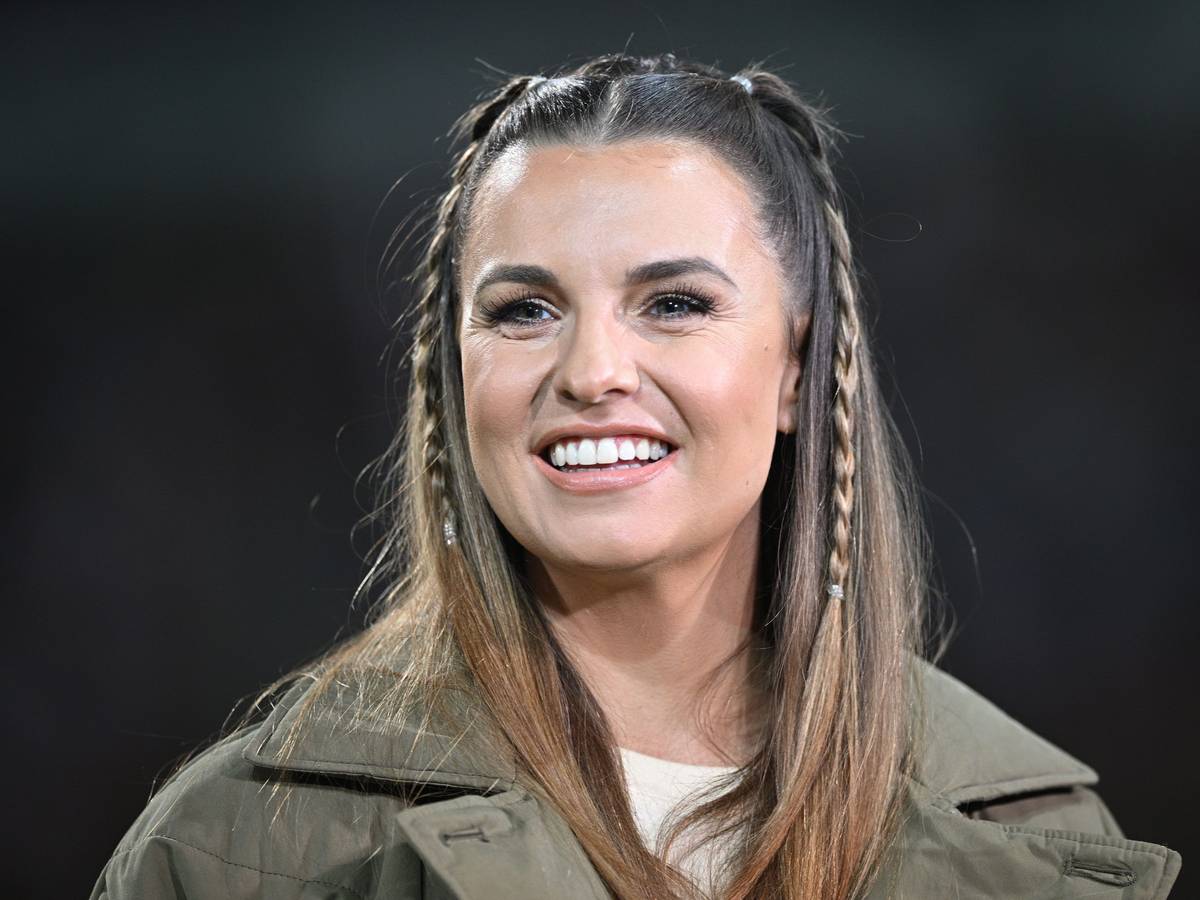 Laura Wontorra lacht am Spielfeldrand.
