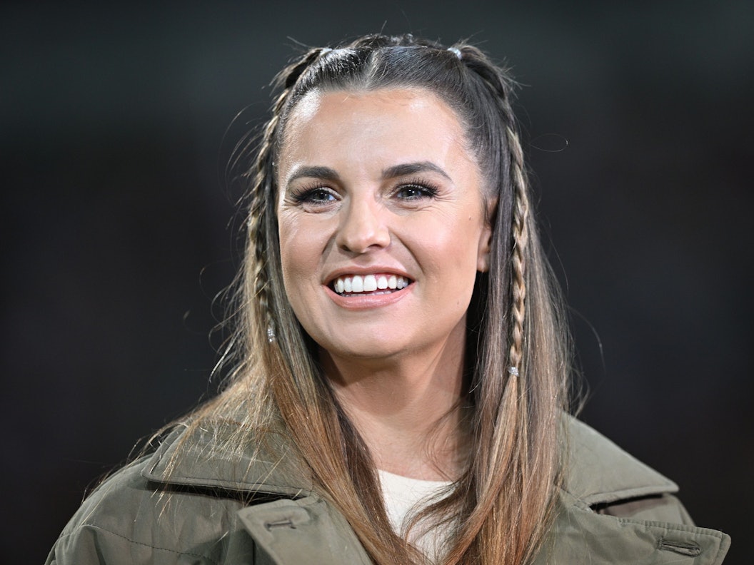 Laura Wontorra lacht am Spielfeldrand.