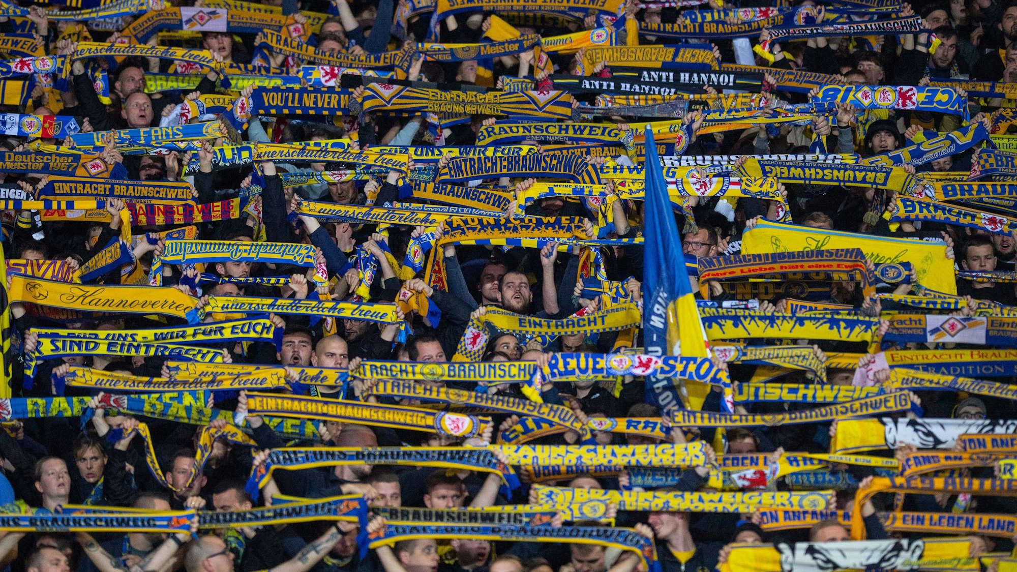 Fans von Eintracht Braunschweig halten beim Pokalspiel gegen den VfL Wolfsburg ihre Schals in die Höhe.