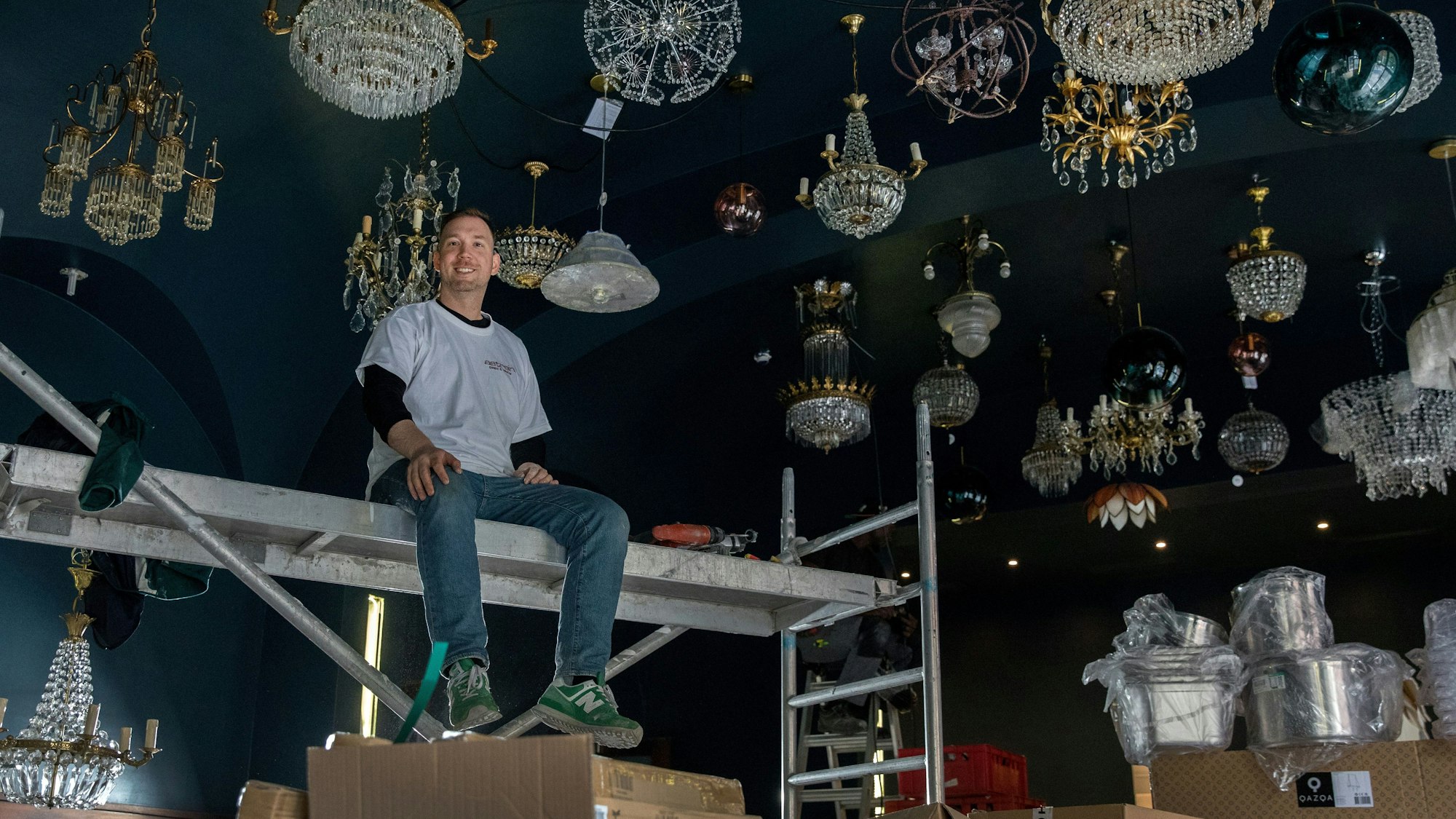 Starkoch Eric Werner sitzt auf einem Gerüst auf der Baustelle in seinem neuen Restaurant Augustin.