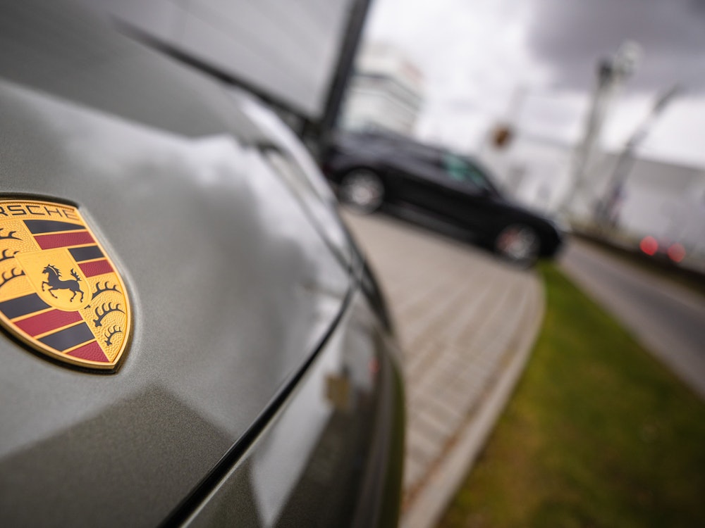 Das Porsche-Logo ist am Firmensitz in Stuttgart-Zuffenhausen auf einem Auto zu sehen.