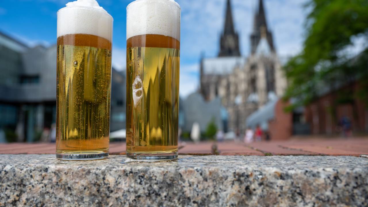 Kölsch im Glas, im Hintergrund ist der Kölner Dom zu sehen.