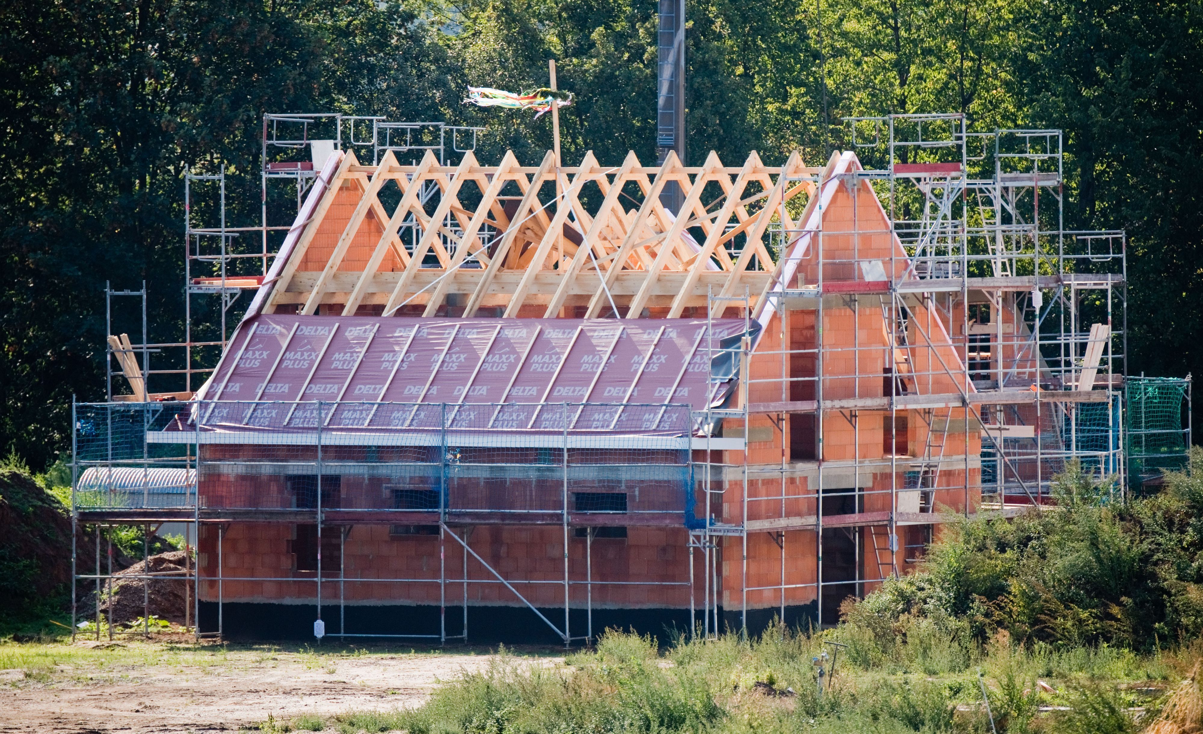 Unser Symbolfoto zeigt einen Rohbau, um den ein Gerüst steht.